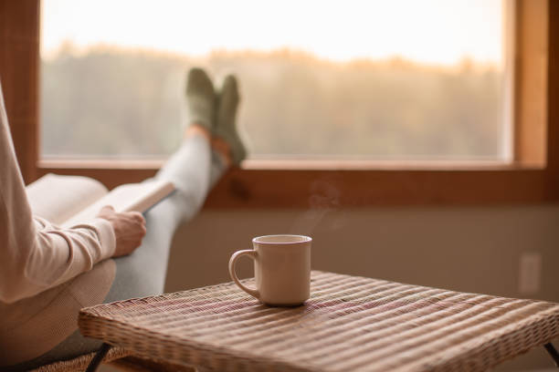 A person sitting quietly by a window with a cup of tea during a calm daily pause